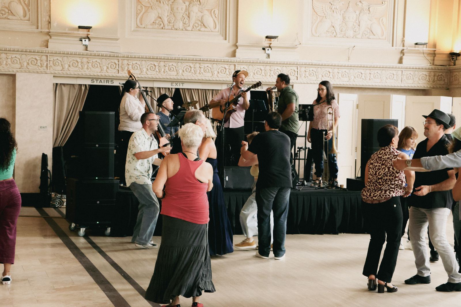 Son Chévere on stage at Hall of the Above in Petaluma while couples dance on the ballroom floor in front.